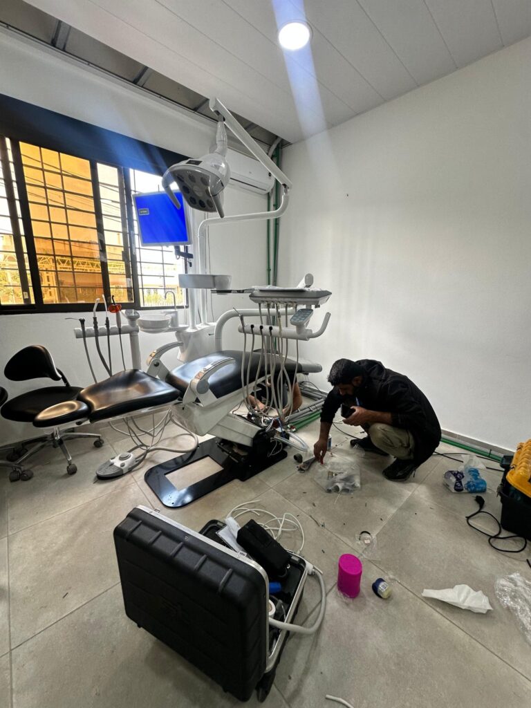 A technician installing the dental chair and integrated units