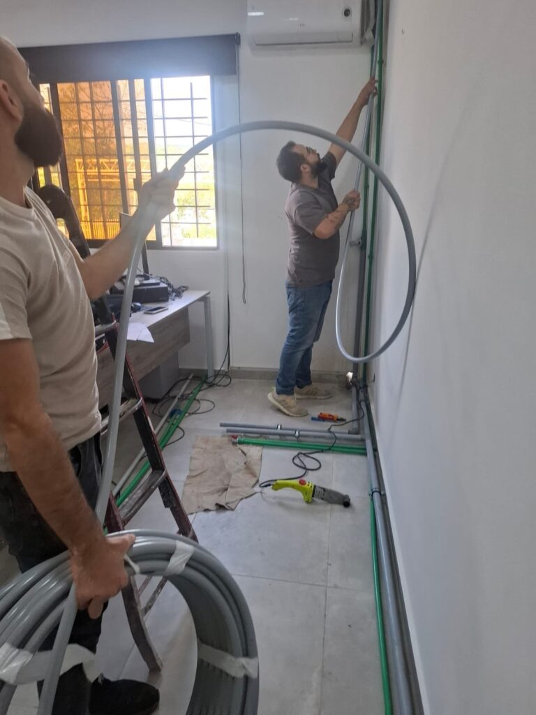 Workers installing the clinic wiring and plumbing during fit-out