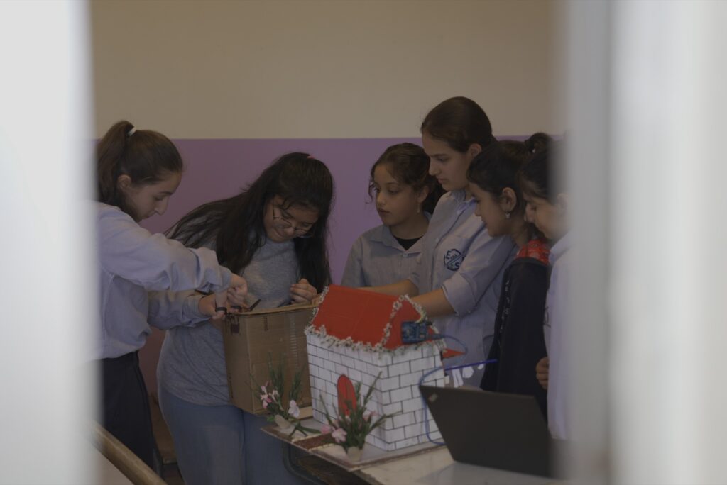 Schoolgirls building a model-house robotics project