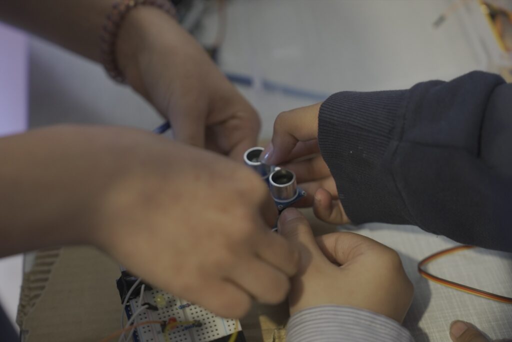Students assembling an ultrasonic sensor on a breadboard
