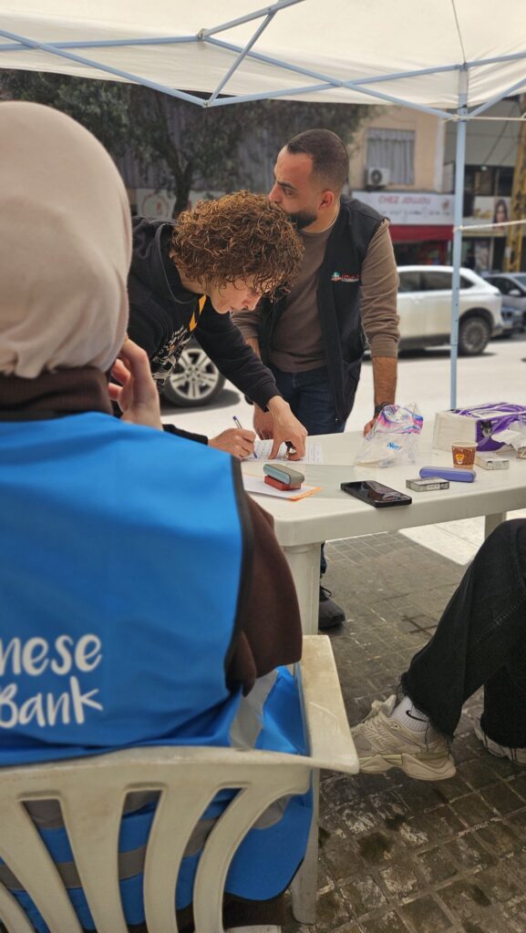 A Lebanese Food Bank volunteer helping register families for food boxes