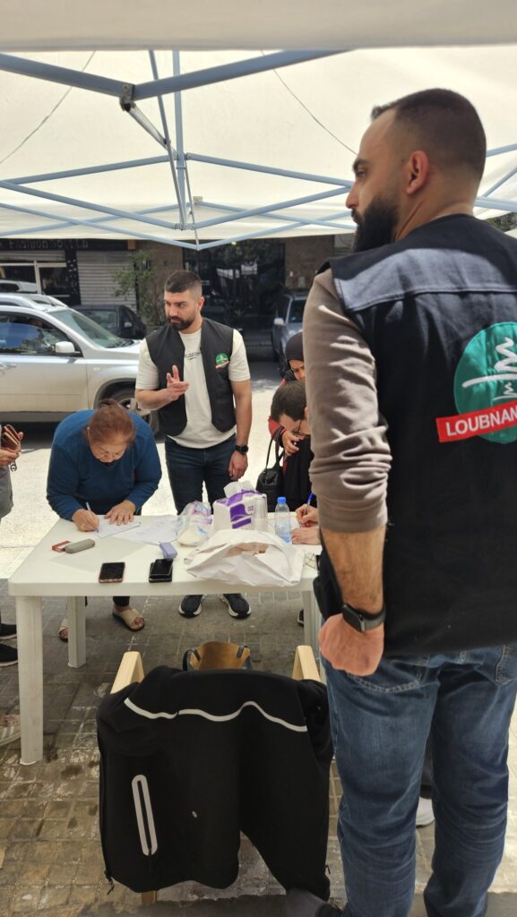 A displaced woman signing for her food box at the distribution