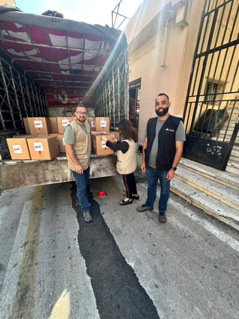 Loubnaniyoun volunteers with PwC-funded hygiene-kit boxes at the delivery truck