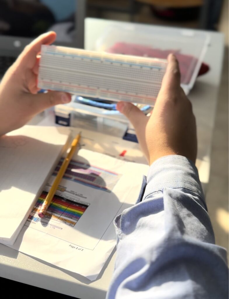 Student holding a breadboard during a robotics class