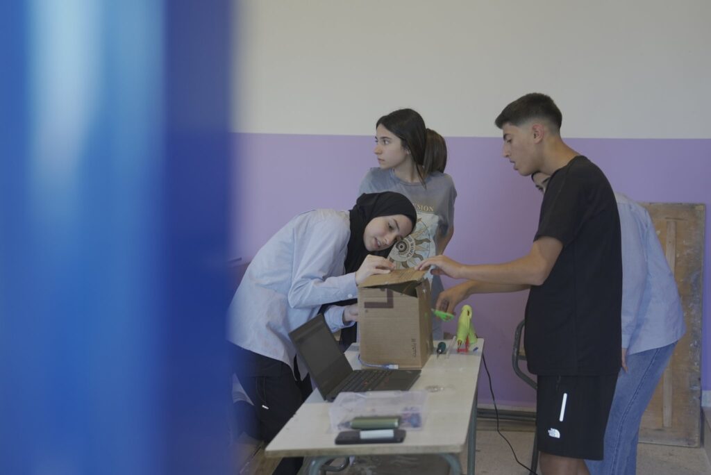 Students building an electronics project with a laptop in class