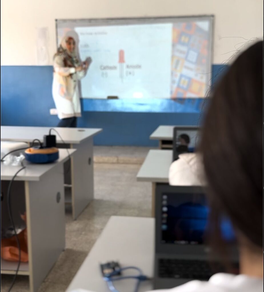 Teacher leading a robotics lesson with a projector